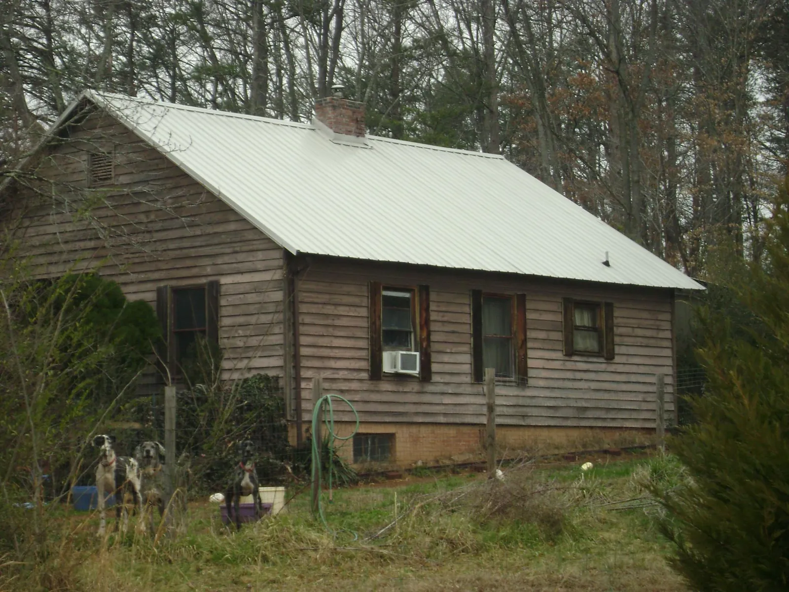 White metal roof on an old wood sided farmhouse, from a Asphalt Shingle Roof Repair job in Spencer